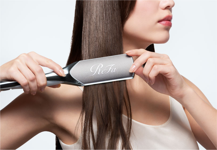 写真：ストレートアイロンを使う女性の様子